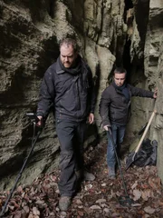 Schatzsucher Jean-Christophe Boulay und Josh Gates untersuchen mit Metalldetektoren eine Höhle in der Nähe von Eisenach, Deutschland.