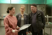 Dr. Gabriele Simkeit (Eva Sixt, l.) bestätigt die Vermutung der beiden Ermittler Linett Wachow (Stefanie Stappenbeck, M.) und Otto Garber (Florian Martens, r.): Das Mordopfer war vor dem Sturz vom Balkon nicht allein in der Wohnung.