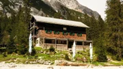 Die Reintalangerhütte im Wettersteingebirge von außen mit Biergarten im Sommer.