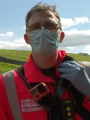 Paul Holmes steht auf dem Feld neben der Trockenmauer.