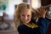 Izzie smiling at the camera with a koala on her shoulder.