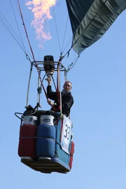 A man operating hot air balloon.