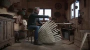Mann fertigt Rattankorb in einer Werkstatt.