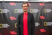 NEW ORLEANS, LA.- Jason Silva standing in front of a step & repeat covered in the National Geographic Channel and Brain Games logos.  (Photo Credit: NG Studios/Chris Van Cleef)