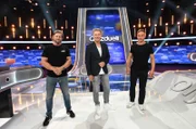 Moderator Jörg Pilawa (M.) mit den Kandidaten des Teams „Schauspiel“: Henning Baum (l.) und Tom Wlaschiha (r.), beide Schauspieler.