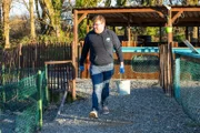 A picture of one of our heroes Sam the animal care manager at SR walking with a bucket of fish.