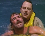 Higgins (John Hillerman, r.) erscheint gerade noch rechtzeitig, um den völlig entkräfteten Magnum (Tom Selleck), vor dem Versinken zu retten.