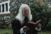 John Lowes, an accused clergyman, sits and read a book.