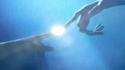 Die Finger berühren sich, als ein Lichtblitz zwischen ihnen erscheint