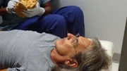 Recon Still- Actor Glenn Kalina on hospital table.