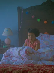 Young Sabrina (played by AJ Lister) reacts to seeing a mysterious figure in her room.
