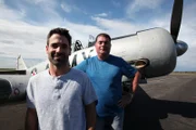 Craig and Victor pose in front of a plane.