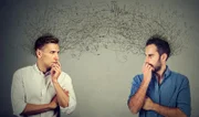 Side profile of two preoccupied businessmen looking at each other exchanging with many thoughts