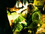 Duane Ollinger sitting on the ground to catch his breath after being rescued from the hole.