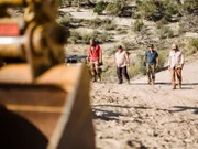 Chad Ollinger, Jamie Dube, Eric Drummond, and Duane Ollinger walking towards the big CAT.