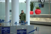 Der CBP-Aufsichtsbeamte Adams trägt Zivilkleidung und einen Rucksack, als er bei seiner verdeckten Arbeit am Philadelphia International Airport in Philadelphia, Pennsylvania, die Gepäckausgabe durchstreift.