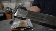 CBP-Beamter Cisneros inspiziert ein Schwert, das in einem verschickten Paket in der Poststelle des JFK International Airport in New York gefunden wurde.