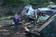 Mary Miller walks among abandoned boats in the Boat Graveyard, looking for parts to build an outhaul in Hangover Cove.