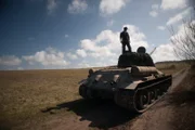 Soldat steht auf einem Panzer.