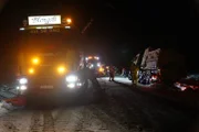 Der Rotator zieht einen nagelneuen Pflugwagen mit Sandstreuer aus dem Graben.