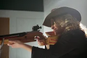 University of Michigan Professor of Physics Katie Freese poses with a pellet gun at a shooting range to show how a DNA detector works to hunt for dark matter.