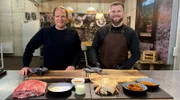 Spitzenkoch Björn Freitag (l.) und der Grill-Blogger und Unternehmer Joscha Bastians (r.) bereiten in dessen Grillschule Pulled Pork und Huhn für den Smoker vor.
