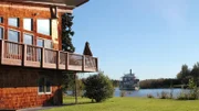 Exterior, side of house with wrap around deck, backyard leads to rivers edge, riverboat moving by, one of the stops in the Greenwoods house search, Chena River house, Fairbanks, Alaska, as seen on Great American Country's Living Alaska