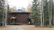 Exterior, octagon shaped house with wood siding, The Folk School wood sign hanging above door, wrap around porch to other house, on one of the stops in the Keeney family house search, Eton Boulevard, Fairbanks, Alaska, Great American Country's Living Alaska.