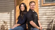 FIxer Upper hosts Chip and Joanna Gaines in the back of the house Kelly and Chip Harp have purchsed. They see this house as an exciting challenge, and have encouraged the Harps to look beyond the mess and consider the financial and creative potential in buying and renovating this house, as seen on HGTV's Fixer Upper. (portrait)