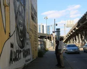 Albert Woodfox, member of the Angola Three who served 43 years in solitary confinement, stands with Morgan Freeman before a mural depicting his imprisonment.