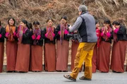 Schülerinnen warten auf eine buddhistische Segnung am Straßenrand in Phunaka (Bhutan)