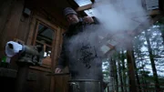 Sam Carlson removes a mink trap that has been boiling in bark tannins at his home in Port Protection.