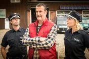 Winnie Bongartz (Kai Maertens, M.) gesteht Mattes (Matthias Schloo, l.) und Melanie (Sanna Englund), dass er sich von seinem Freund und Geschäftspartner ohne dessen Wissen Geld geliehen hat.