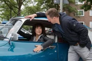 Harry (Maria Ketikidou, l.) darf einen Oldtimer ihres Freundes zur Probe fahren. Piet Wellbrook (Peter Fieseler, r.) will sie überreden, den Oldtimer für eine Dienstfahrt zu benutzen.