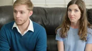A couple sits on the couch.