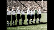 Acht Mitglieder der englischen Fußballmannschaft beim Hitlergruß im Olympiastadion in Berlin. Hinter ihnen schaut die Menge zu.
