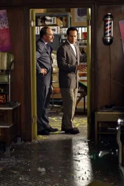 In einem Friseursalon, in dessen Hinterzimmer illegal Glücksspiel betrieben wird, kommt es zu einer Schießerei. Captain Leland Stottlemeyer (Ted Levine, l.) und Adrian Monk (Tony Shalhoub, r.) untersuchen den Tatort ...