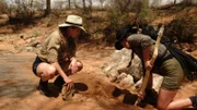 Amber und Serena Shine graben ein Loch im Rift Valley