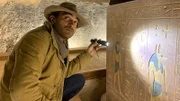 Ramy Romany looks at hieroglyphics with a flash light.