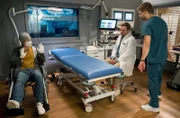 Joshy Binder (Laurids Schürmann, l.) soll am Knie untersucht werden. Mit seiner Schutzkleidung sorgt er bei Marc Lindner (Christian Beermann, 2.v.r.) und Mikko Rantala (Luan Gummich, r.) für Irritation bei den Ärzten.