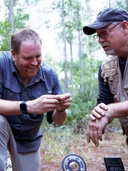 L-R: Josh Gates und Steve Carr finden einige alte Münzen an einem geheimen Ort in Fruta.