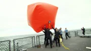 Auf dem deutschen Kriegsschiff "Nordrhein-Westfalen" bereitet die Besatzung einen drei mal drei Meter großen Pressluftballon vor.