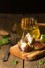 Figs, cheese and honey snack on a wooden board