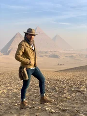 Ramy Romany standing in front of the Pyramids.