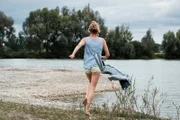Eva beschließt (Luise Bähr), den Dreck von der Camperreparatur im See abzuspülen.