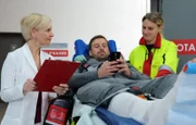 Daniel Kramer (Ben Blaskovic, mi.) wird von der Notärztin (Komparsin, re.) in die Sachsenklinik eingeliefert. Dort übernimmt Dr. Kathrin Globisch (Andrea Kathrin Loewig, li.) den Patienten, der allerdings nur Augen für seine Dating-App hat.
