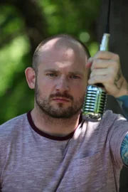 Rapper Mac Lethal holds a mic.