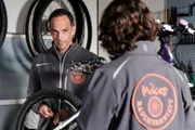Mike (Harry Blank) versucht, sich in seiner Werkstatt mit Arbeit abzulenken, während Till (Marinus Hohmann, rechts) verliebt mit Lien schreibt.