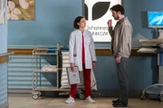Dr. Krieger (Milena Straube, l.) trifft auf dem Gang auf Kriminalkommissar Emiliano Catalfo (Michele Cuciuffo). Er lässt sich nur widerwillig zu einer Untersuchung überreden.