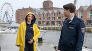 Austauschpolizist Eddi Jansons (Gustavs Gailus, r.) ist besorgt um seine schwangere Kollegin Paula Moorkamp (Stella Hinrichs, l.). Übertreibt er es ab und zu mit seiner Fürsorge? Paula hat einen Vorschlag für ihn.